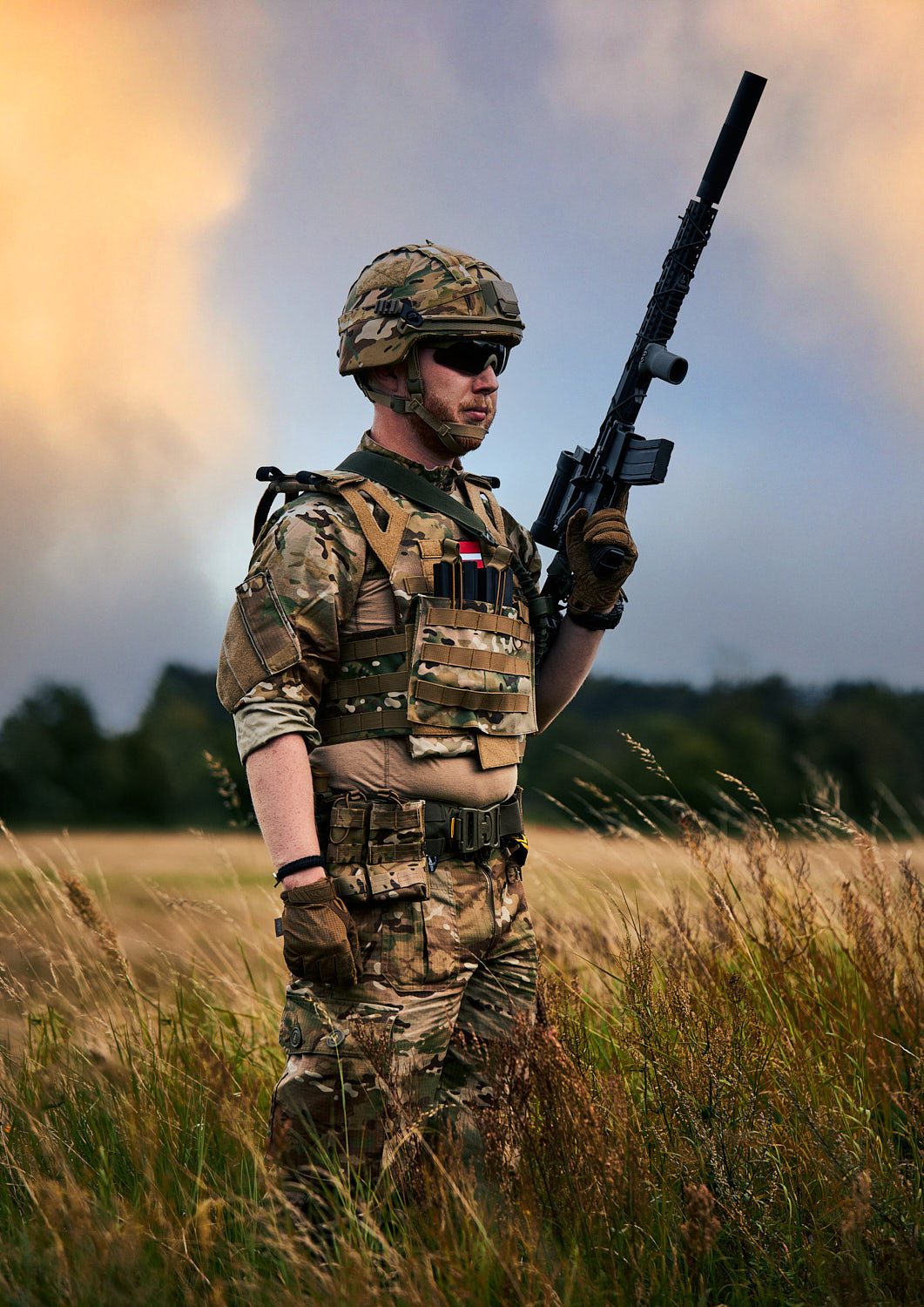 Portræt af soldat med gevær i en mark ved solnedgang